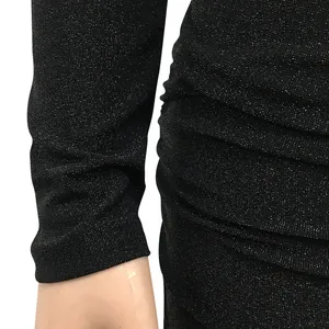 Detail shot of black shimmery glitter fabric and side ruching on a long sleeve dress
