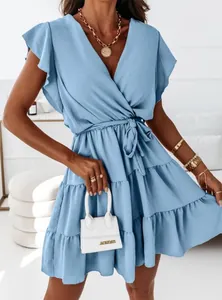 Close-up detail of a light blue V-neck dress featuring ruffled sleeves and a tiered skirt
