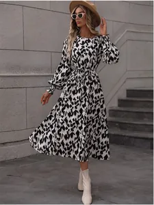 Full length view of a black and white leopard print long sleeve dress with a waist tie.