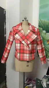 Close-up view of a red and white plaid cropped blazer jacket on a tailor mannequin