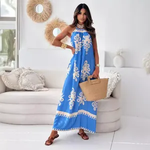 Vibrant blue floral print halter maxi dress with backless design for summer resort wear.
