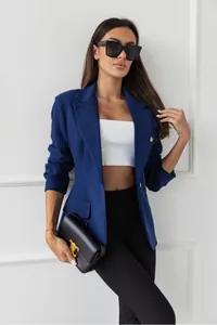 Modella che indossa un blazer blu navy sartoriale con eleganti bottoni dorati.