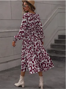 Detail view of leopard print long-sleeve dress with tie-waist and flared skirt.