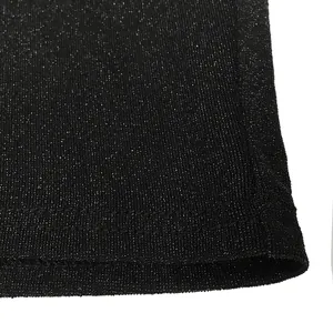 Detailed macro view of high-quality black glittering fabric with metallic threads on dress hem