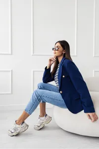 Elegante blazer doppiopetto blu scuro da donna indossato in uno studio professionale
