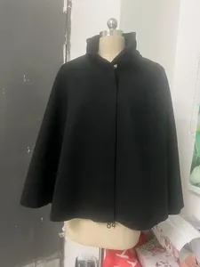 Vue détaillée d'un élégant manteau cape en laine noire exposé sur un mannequin de tailleur
