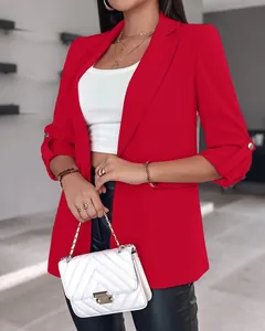 Close-up of a vibrant red blazer featuring stylish rolled sleeves with gold buttons.