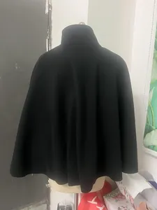 Vue arrière détaillée d'une cape en mélange de laine noire avec col montant sur mannequin