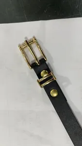 Détail de la boucle dorée élégante et de la ceinture noire pour manteau en laine