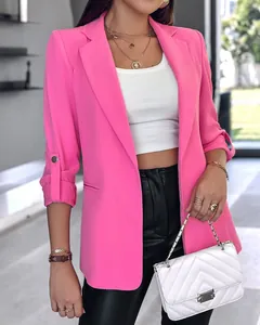 Detailed shot of a bright pink blazer with rolled sleeves and stylish white crop top