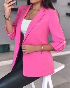Close-up detail of a vibrant pink women's blazer featuring chic rolled-up tab sleeves design.