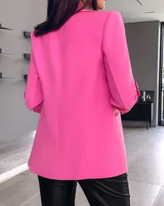 Back view of a fashionable solid vibrant pink blazer with trendy rolled-up sleeves