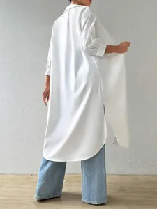 Back view detail of a long white oversized solid color shirt cardigan with side slits