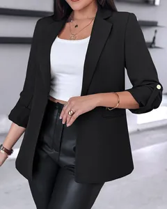 Close-up detail of women's black fashion blazer showing roll-up sleeves with gold button tab