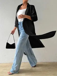 Detail view of women's long black cardigan shirt showing fabric flow and movement