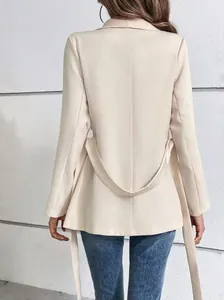 Detalle de la espalda de un blazer beige entallado con cinturón y manga larga