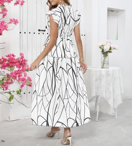 Back view of a white abstract print maxi dress with ruffles and a flared hem.