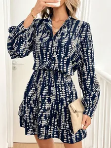 Detail view of a stylish navy blue abstract print dress with V-neck and ruffled hemline