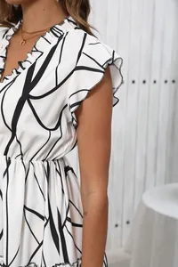 Close-up of V-neck with ruffled edges on a black and white geometric print dress.