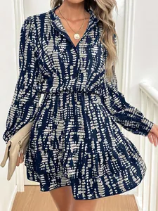 Close-up detail of a blue abstract print dress with long sleeves and ruffled hem.