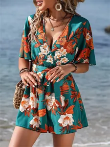 Close-up of tropical floral print jumpsuit featuring ruffle sleeves and wrap V-neckline