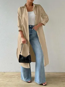 Detailed view of long tan button-down tunic shirt styled with jeans and a handbag