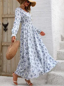 Detailed view of white floral V-neck maxi dress with long sleeves in outdoor setting