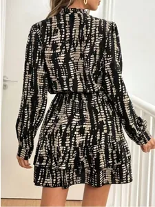 Back view of long sleeve ruffled dress with black and white abstract print