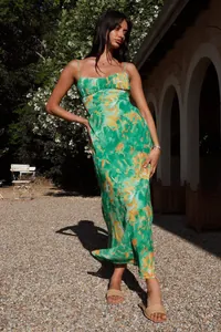 Elegant French style floral slip dress in green and yellow print, showcased in sunny garden