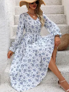 Blue floral long sleeve V-neck maxi dress with smocked waist sitting on steps
