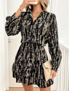 Detailed view of fashionable V-neck dress with abstract print and ruffled hem