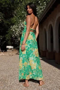 Detailed back view of a vibrant green floral maxi dress featuring elegant spaghetti straps
