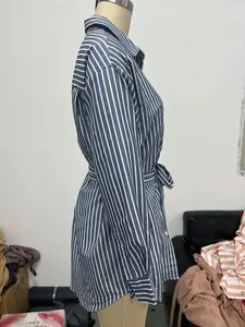 Vista laterale di un abito a camicia a maniche lunghe a righe blu e bianche con lacci