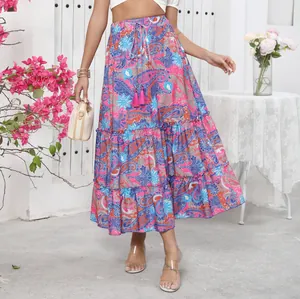 Detailed view of bohemian tiered maxi skirt with vibrant paisley print and tassels