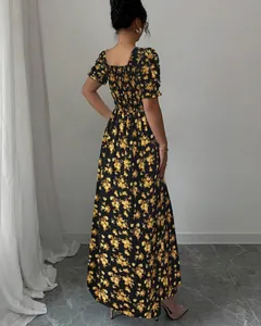 Rear view of elegant yellow floral maxi dress featuring a smocked bodice and ruffle sleeves
