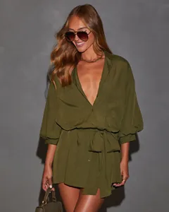 Detailed view of the olive green long-sleeved tie-waist shirt dress on a model