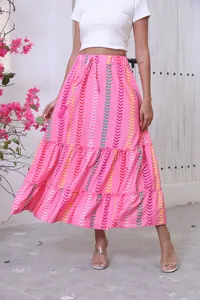 Detail of a pink bohemian maxi skirt featuring colorful chevron print and tiered hem