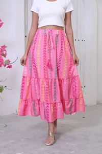 Detailed view of bohemian pink tiered maxi skirt with vibrant chevron patterns on model