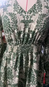 Detail view of a V-neck floral dress highlighting the smocked elastic waist and damask pattern
