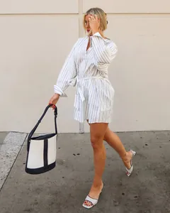 Dettaglio di un abito a camicia a righe con scollo a V e cintura annodata in vita