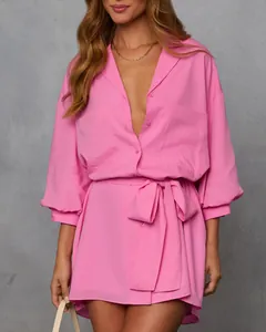 Detail view of a vibrant pink long sleeve shirt dress with a stylish waist tie knot.