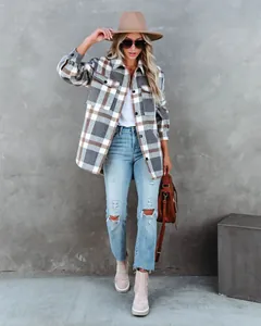 Dames geruite flanellen overshirt gestyled met gescheurde jeans en een bruine hoed.