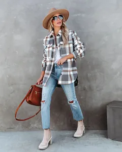 Streetstyle-weergave van een vrouw in een geruite wollen jas en een gescheurde jeans