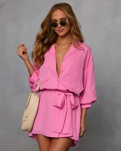 Fashionable pink long-sleeve shirt dress detail featuring an elegant waist tie and button front