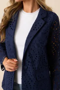 Detailansicht eines marineblauen Blazers mit eleganten floralen Lochstickerei-Mustern