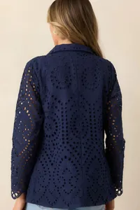 Detailansicht der Rückseite eines dunkelblauen Blazers mit filigranen Lochstickerei-Mustern