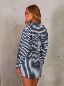 Elegante abito a camicia a maniche lunghe a righe blu e bianche con cintura in vita.