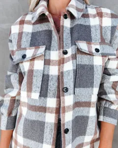 Detailopname van een grijs en bruin geruit wollen jack met knoopdetails en textuur.