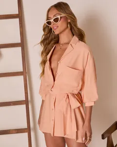 Detail view of the apricot shirt dress featuring a front pocket and stylish tied waist belt