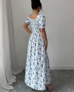 Back view showing details of an elegant blue floral puff sleeve maxi dress with smocked bodice